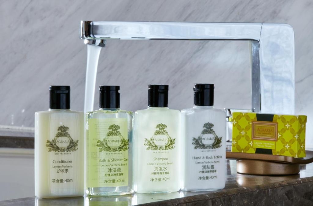 a group of four bottles of soap on a counter at The Azure Ningbo, Vignette Collection by IHG in Ningbo