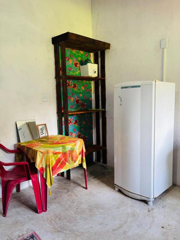 a table with a table cloth next to a refrigerator at Aroeira Suite in Conceição da Barra
