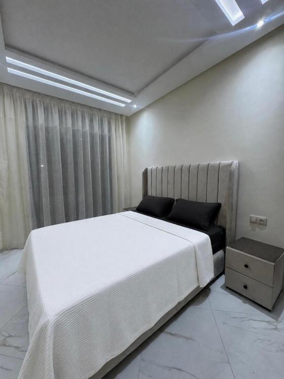 a bedroom with a large white bed and a window at Nador hola corniche in Nador