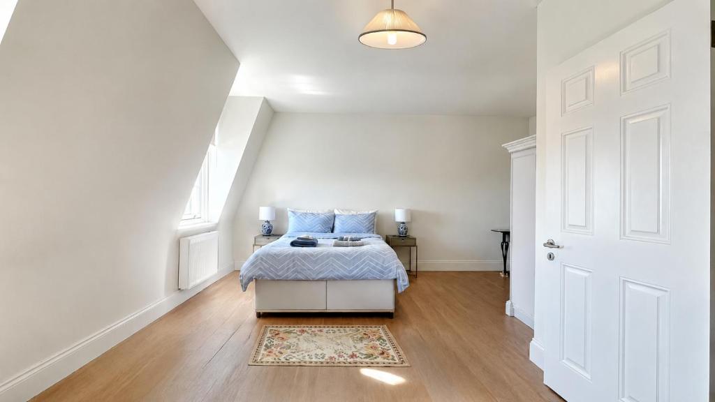 a bedroom with a bed with blue pillows on it at Spacious Guest Studio - En-Suite - Central - Calm View in London