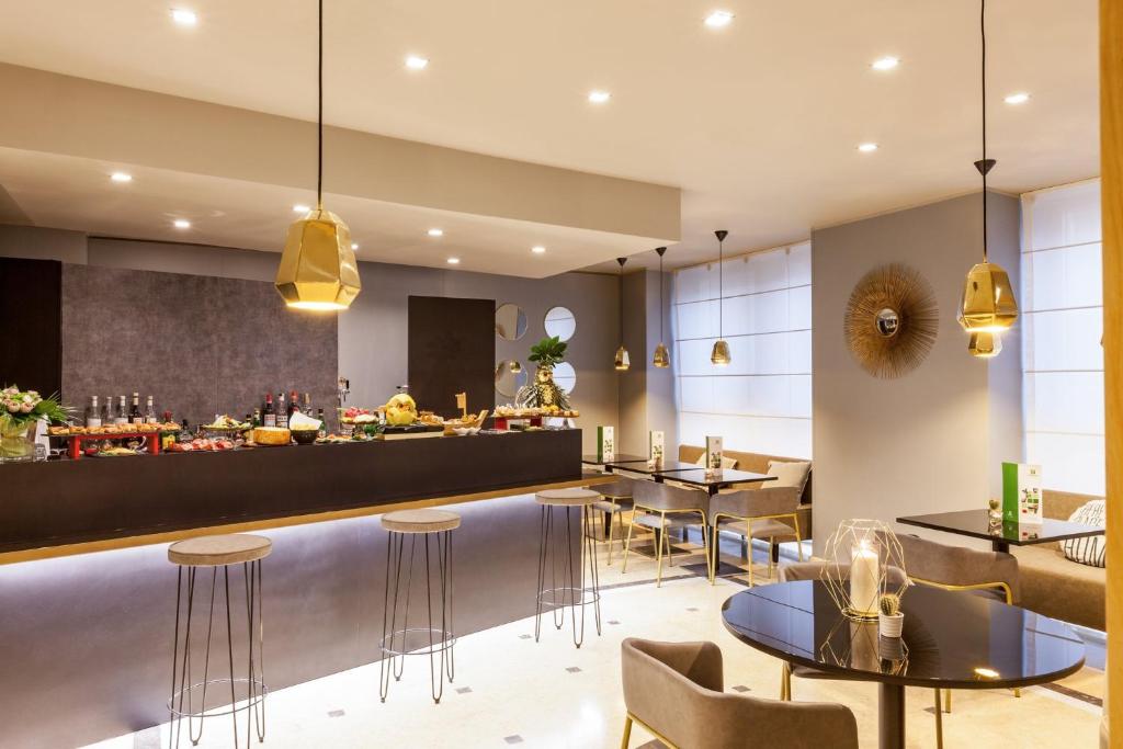 a restaurant with tables and chairs and a bar at Holiday Inn Milan Garibaldi Station by IHG in Milan