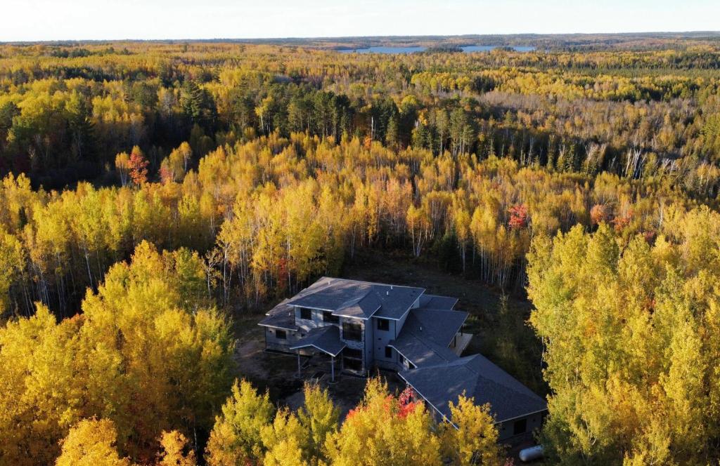 an aerial view of a house in the middle of a forest at Cedar Studios at Whitetail Estates in Babbitt