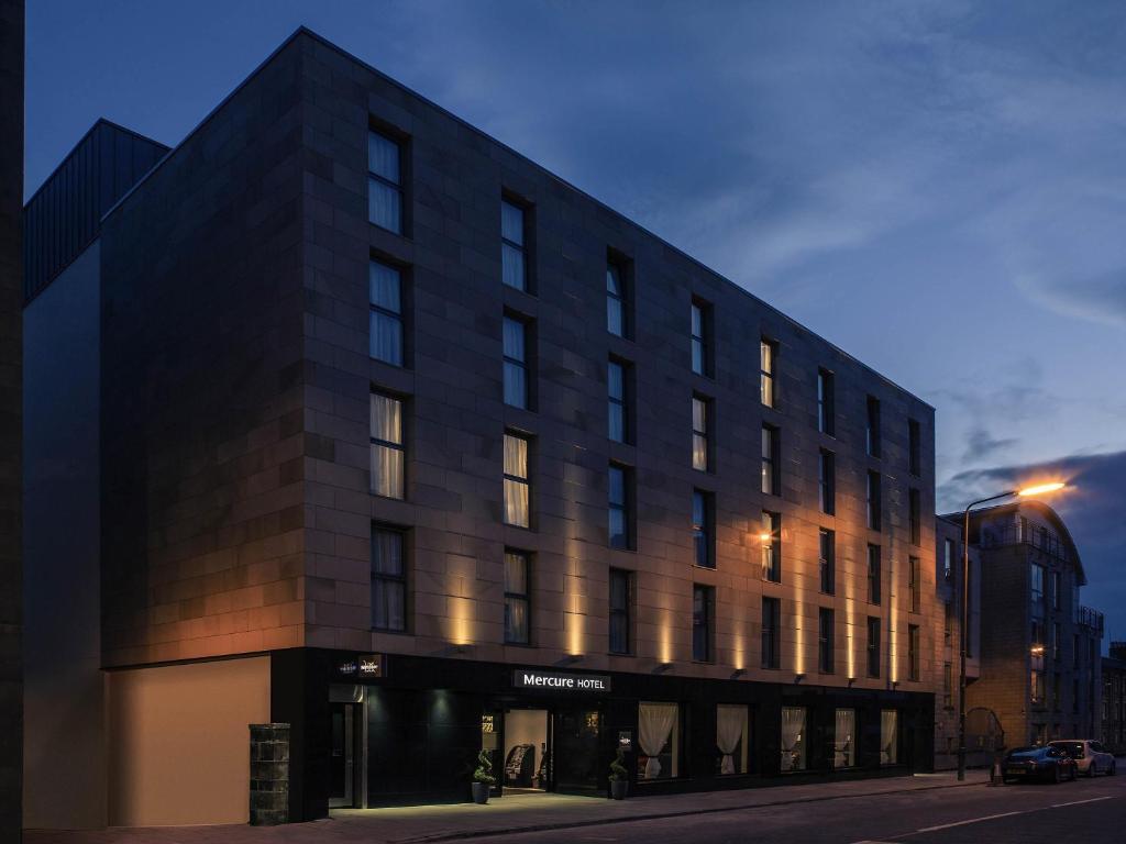 a large black building on a street at night at Mercure Edinburgh Haymarket in Edinburgh