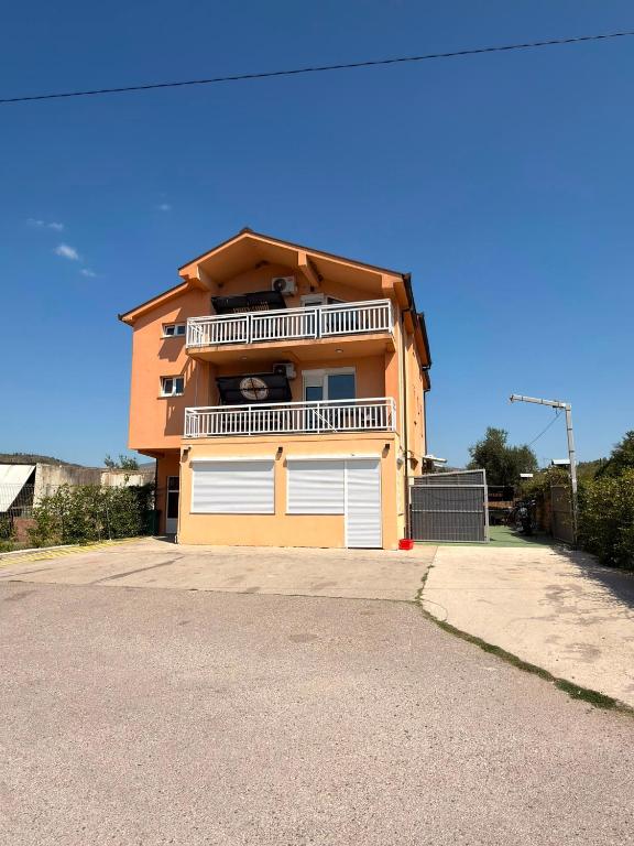 a house with two white garage doors on a street at Apartmani Ana in Čapljina
