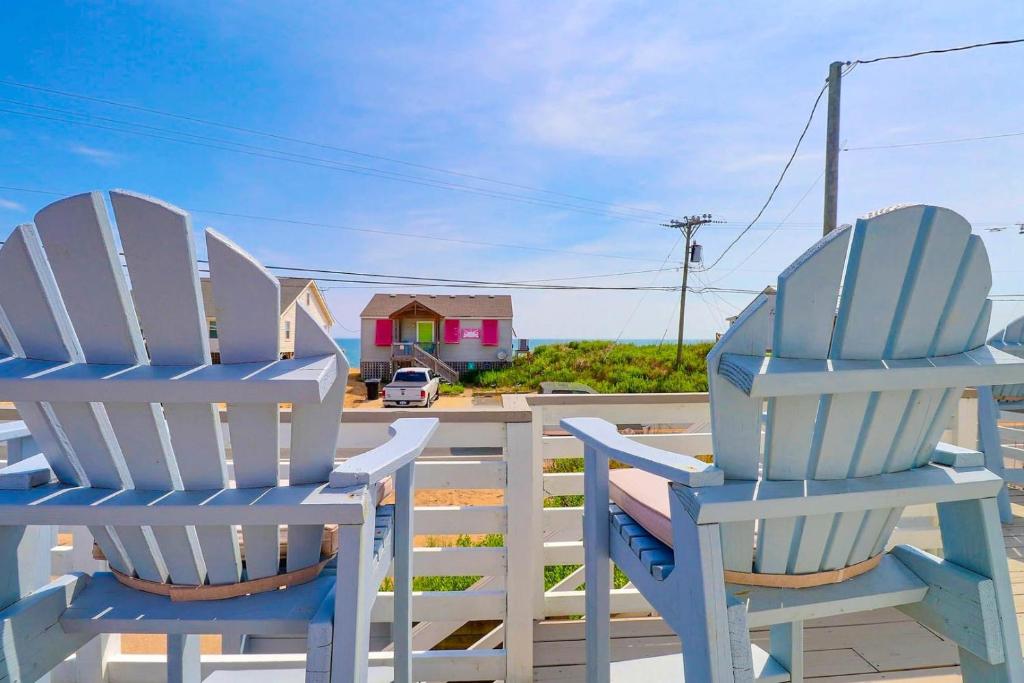 two blue chairs sitting on a deck with a house at 4119 - The Dolphin Boat in Kitty Hawk