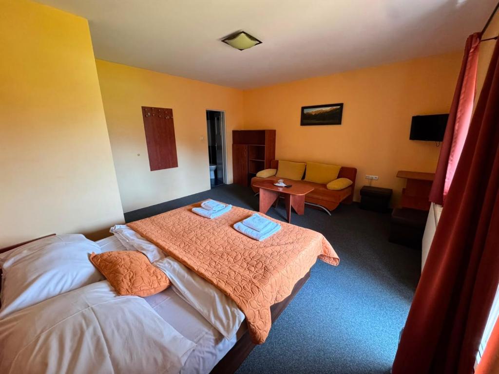 a bedroom with a bed with two towels on it at Penzión Timea Zuberec in Zuberec