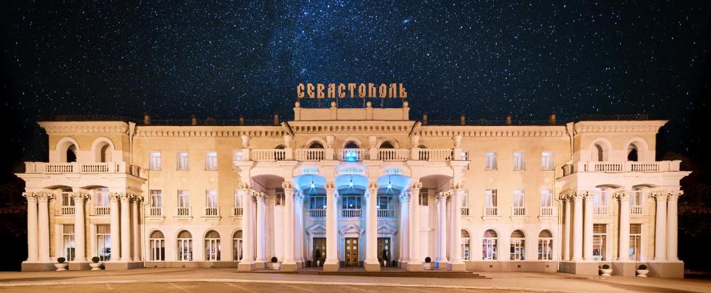 un gran edificio blanco con luces azules. en Sevastopol Hotel, en Sevastopol