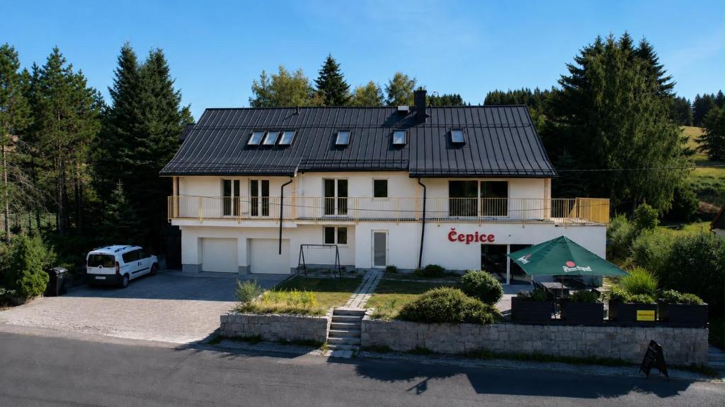 a house with a car parked in front of it at Horský penzion a bistro Čepice in Pernink