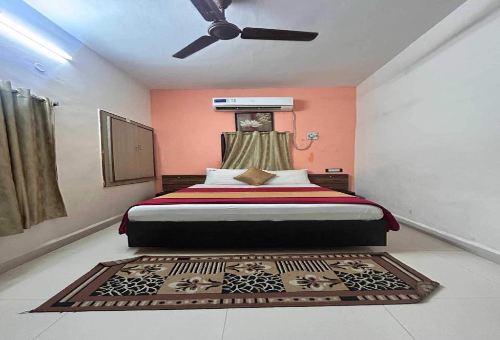 a bedroom with a bed and a ceiling fan at Hotel O Kurnool Railway Station Road in Kurnool