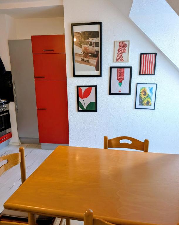 a dining room with a wooden table and pictures on the wall at Crew Base Zeltweg in Zeltweg
