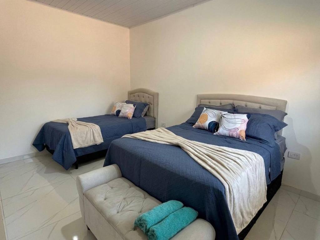a bedroom with two beds and a couch in it at AP 6 C/Garagem>Ar>Wifi>Cozinha>Tv Disney+>Pet free in Ji-Paraná