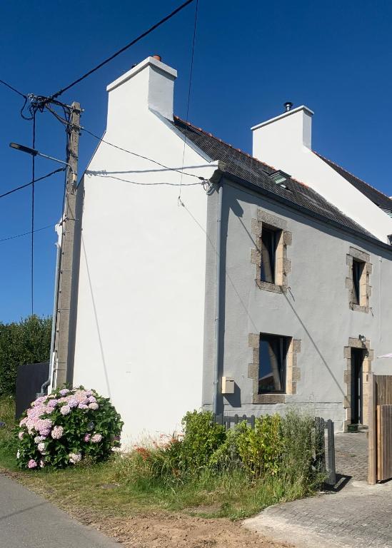 a white house with flowers in front of it at Ti Bihan in Plouguerneau