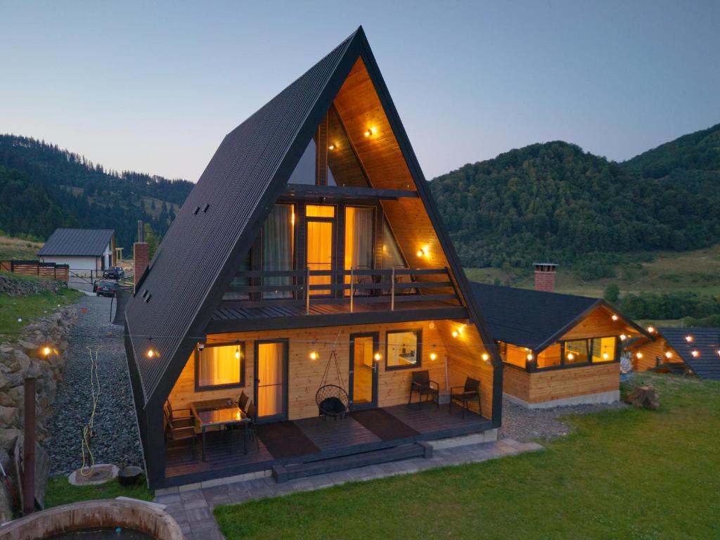 a large house with a large gambrel roof at Cabana Magia Muntelui in Prisaca Dornei