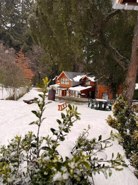a house with snow on the ground in front of it at Portal del Manzano in Villa La Angostura