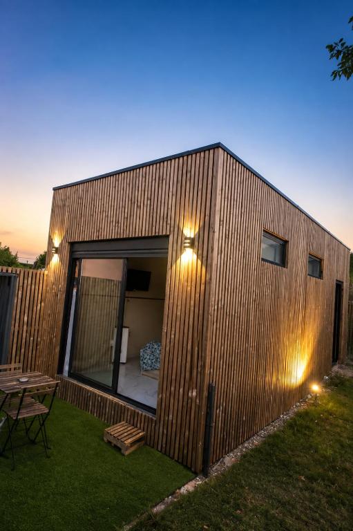 a small wooden building with a table in a yard at Chez Aurel et Nico. in La Lande-de-Fronsac
