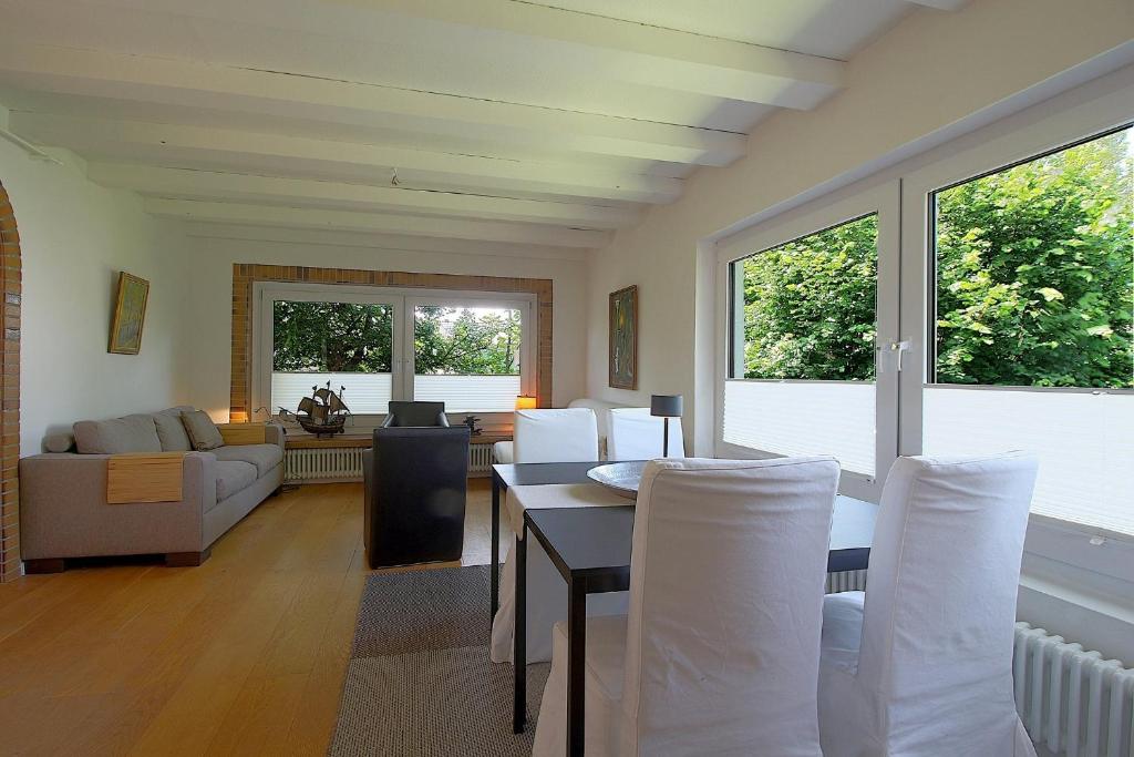 a living room with a table and white chairs at NS 6 Möwenkoje Wremen in Wremen