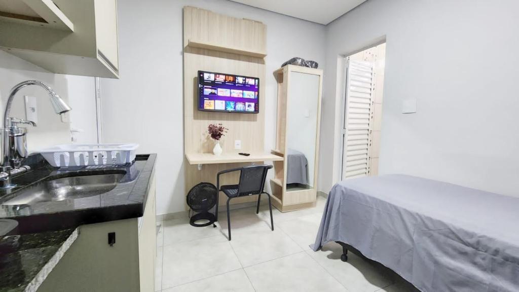 a bathroom with a sink and a bed in a room at Studio 1 in Jundiaí