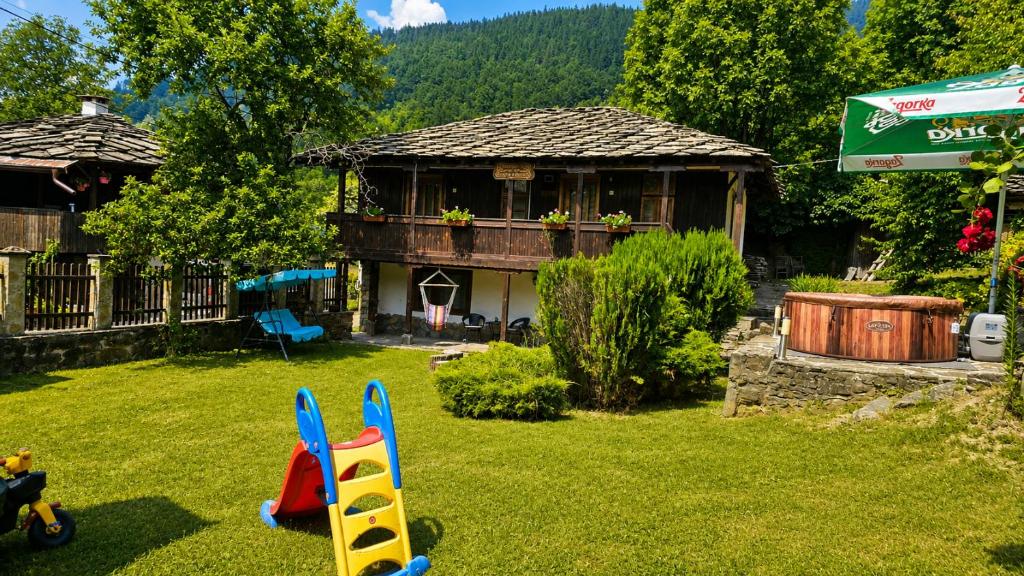 a house in a yard with a toy house at Къща за гости Хитър Петър in Apriltsi