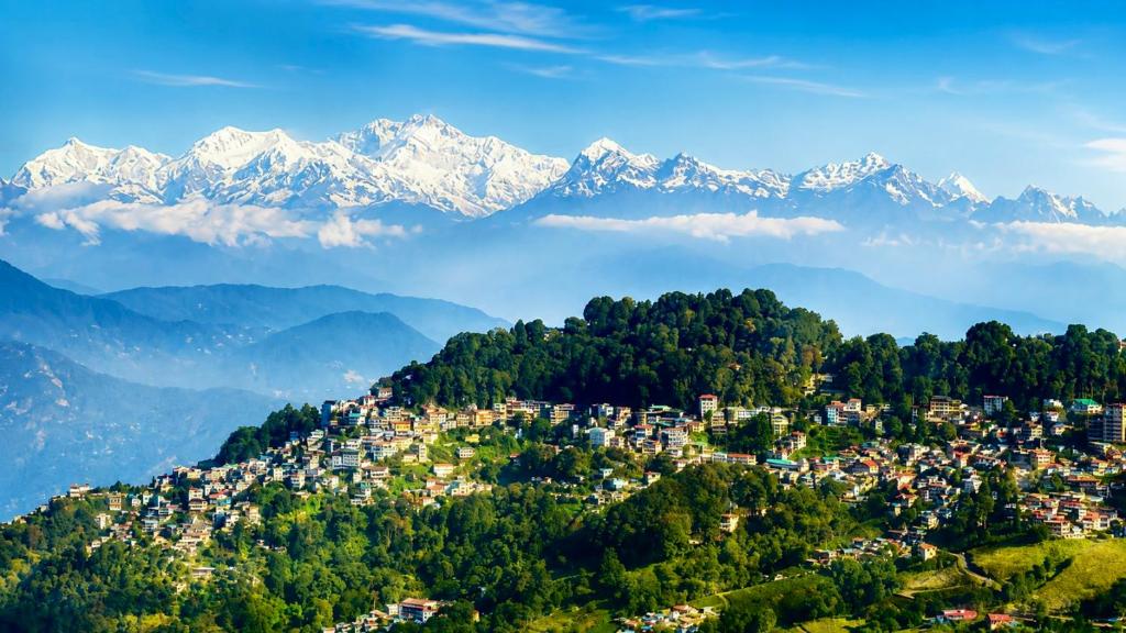 a city on a hill with mountains in the background at The Manzil Boho in Darjeeling