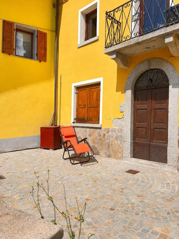 a yellow building with two orange chairs in front of it at casa zanna bianca in Vione