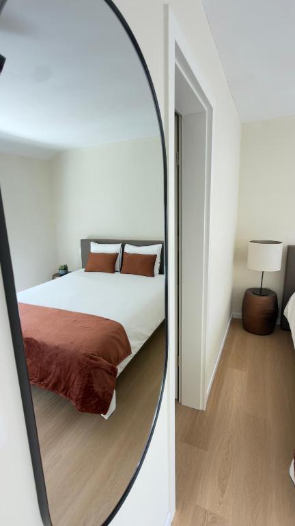 a mirror reflecting a bed in a bedroom at Kerbault Suites - Martelange in Martelange