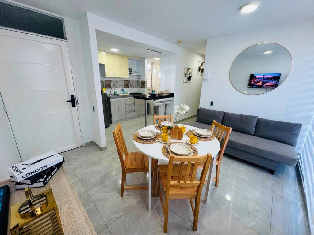 a living room with a table and chairs and a couch at Apartamento central Moderno de lujo y con piscina in Villavicencio