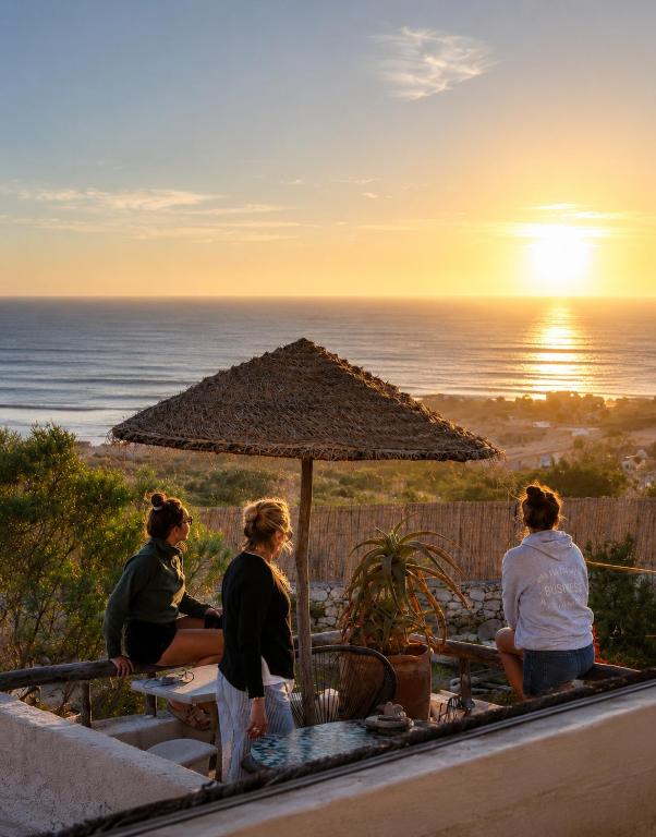 a group of women sitting at a table watching the sunset at Surf HouseMaroc in Essaouira