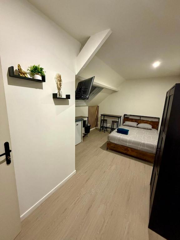 a bedroom with a bed and a desk in a room at Studio relax in Villeneuve-Saint-Georges