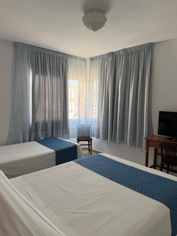 a hotel room with two beds and a television at Plaça Vella in Sant Carles de la Ràpita