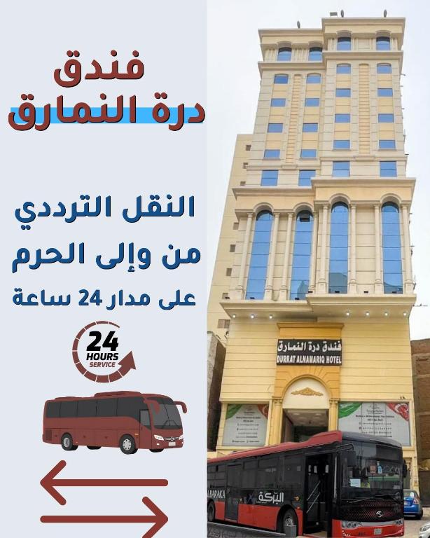 a bus is parked in front of a building at فندق النمارق المتميزة توصيل مجاني للحرم Al Namarq Distinguished Hotel Free hourly shuttle to Al Haram in An Naqāʼ