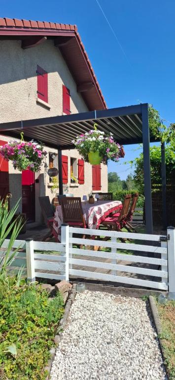 a white fence in front of a house with flowers at Cocon Nature in La Bourgonce