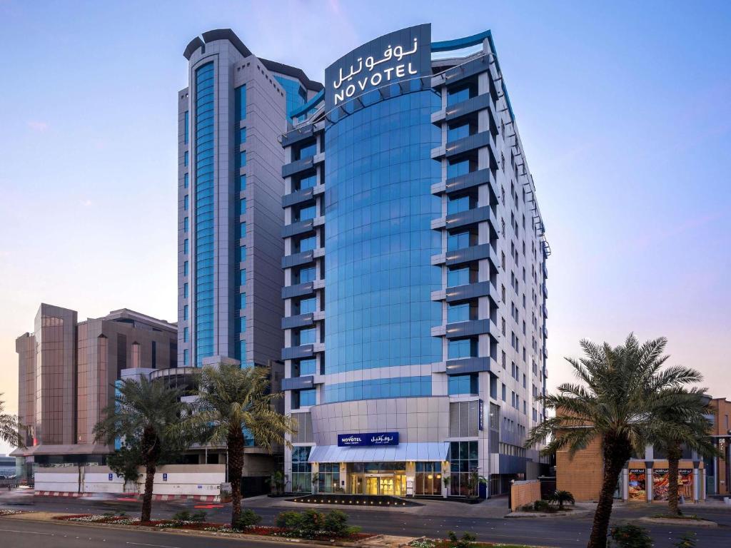a large building with a sign on top of it at Novotel Jeddah Tahlia in Jeddah