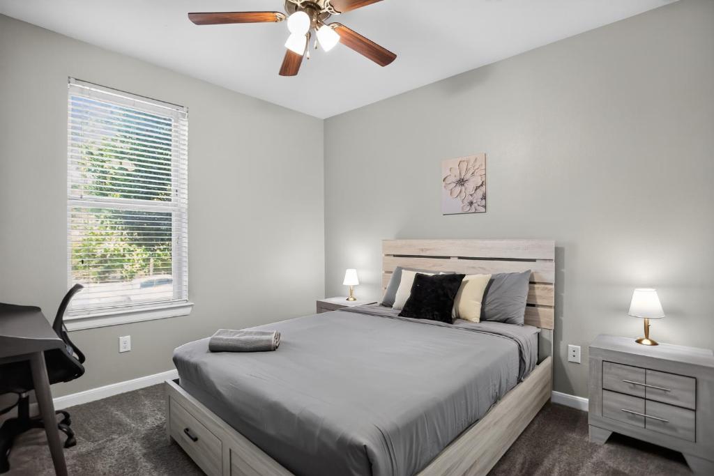 a bedroom with a bed with a ceiling fan and a desk at Spacious 1-bedroom apartment with modern comforts in Dallas