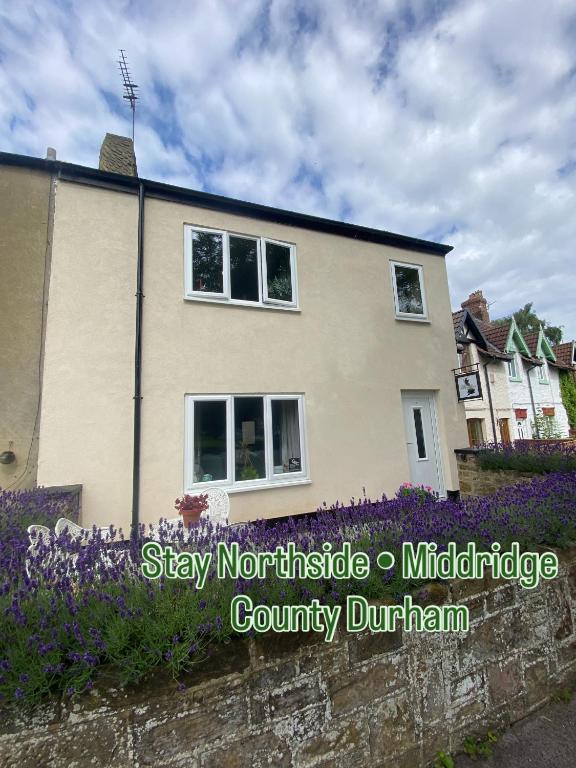 a house with purple flowers in front of it at 2-Bed Village Country Cottage with Free Parking and Pub - County Durham in Newton Aycliffe