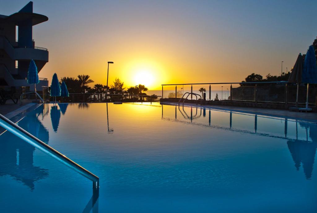 an empty swimming pool with the sunset in the background at Terraza de Amadores in Puerto Rico de Gran Canaria