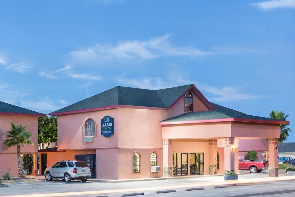 a building with a car parked in front of it at Oasis Inn in San Angelo