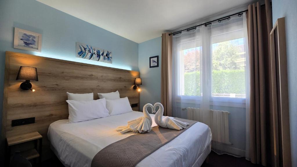 a hotel room with a bed and a window at Hôtel Le Pommeil in Guéret