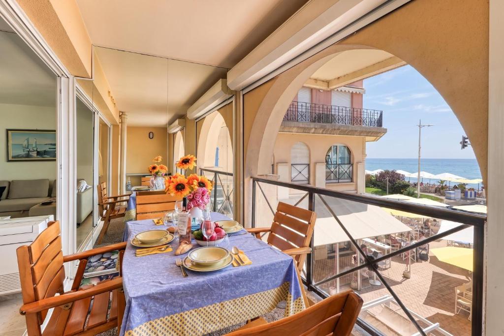a dining room with a table and a balcony at Victoria Palace Elegant Apt with Terrace in Menton