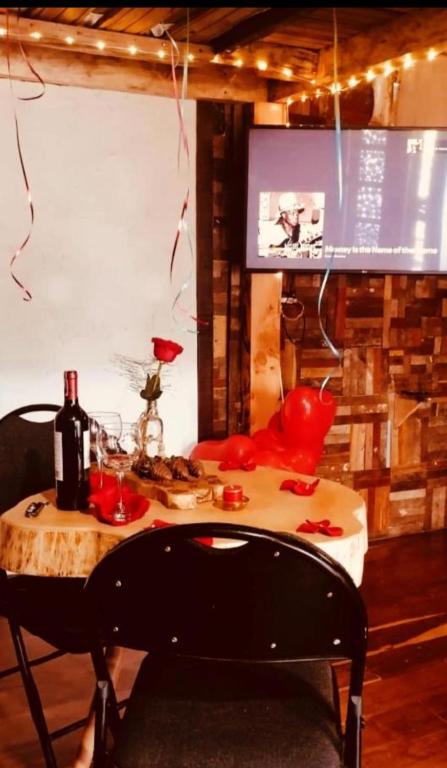 a table with a bottle of wine and a television at Cabaña en la Calera con Sauna in La Calera
