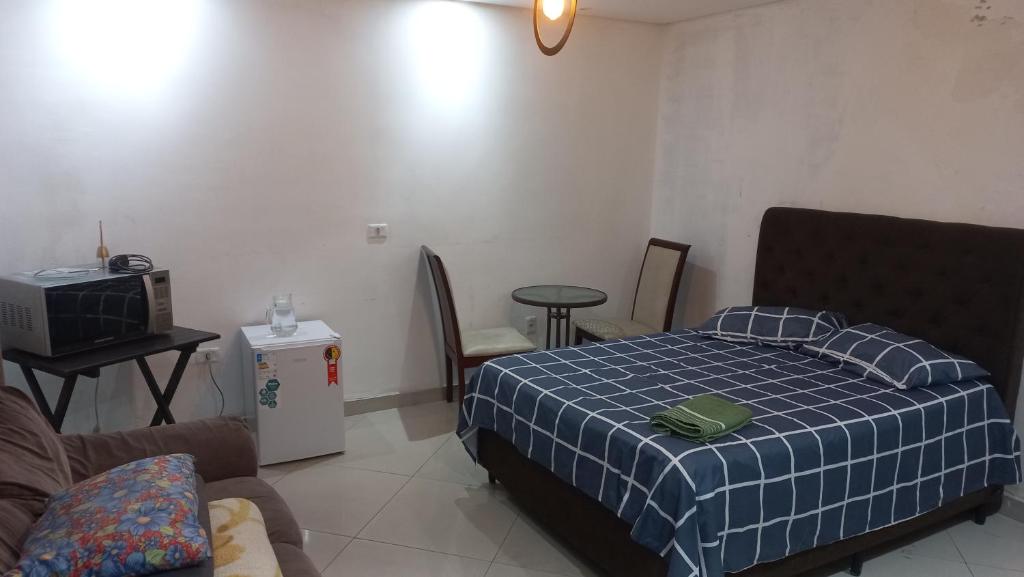 a bedroom with a bed and a couch and a tv at suite Perto do aeroporto de guarulhosAv Jovita 401 in Guarulhos