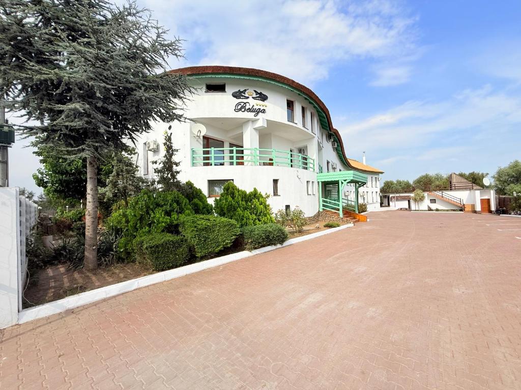 a large white building with a red roof at Pensiunea Beluga in Murighiol