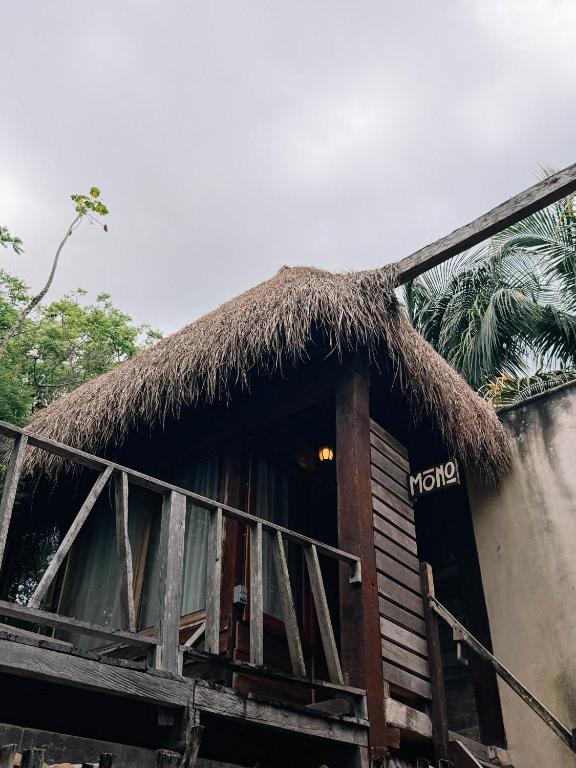 a hut with a thatched roof and a porch at BOA BOA Bacalar in Bacalar