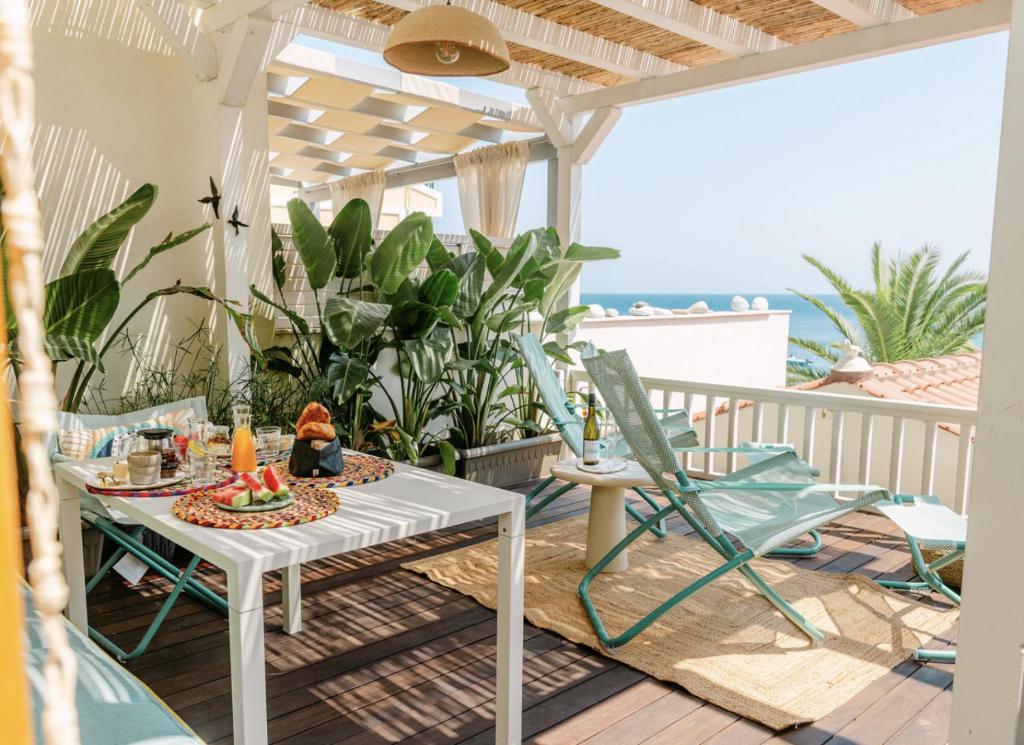 a patio with a table and chairs on a balcony at Aegean Stories pelagos suites in Avlákia