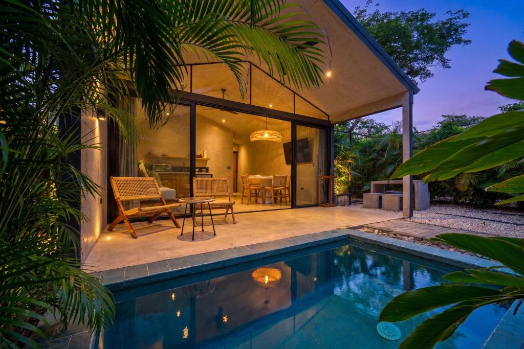 a house with a swimming pool next to a house at Selvatico Tamarindo Villas in Tamarindo
