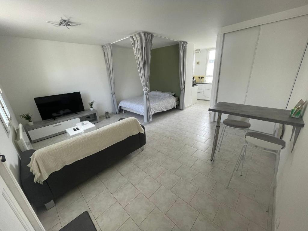 a living room with a bed and a desk at Chez Ben et Lou in Envermeu