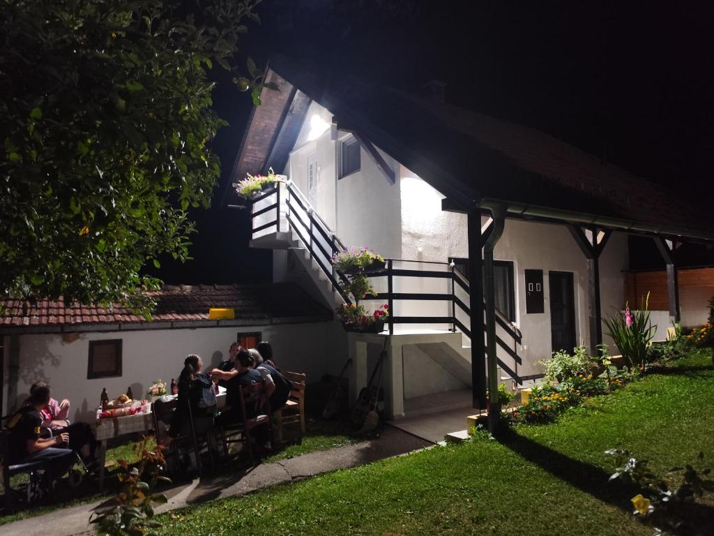 a group of people sitting at a table outside a building at Apartmani KOSMOS in Rudnik