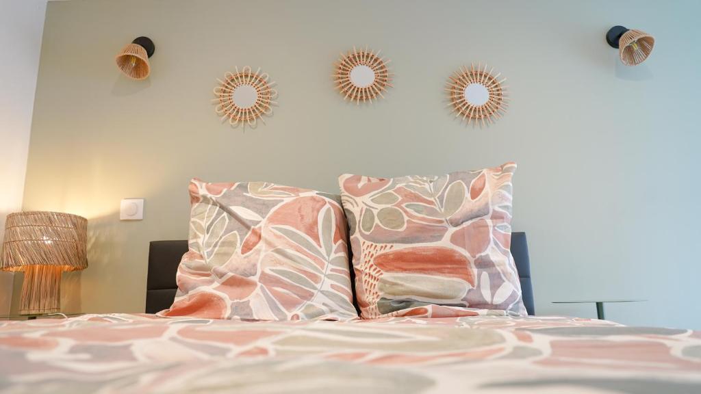 a bedroom with a bed with pillows and mirrors on the wall at Le Perchoir d'Orthez in Orthez