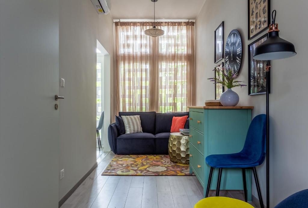a living room with a couch and a blue chair at Piccoleto Bianco in Badacsonytomaj
