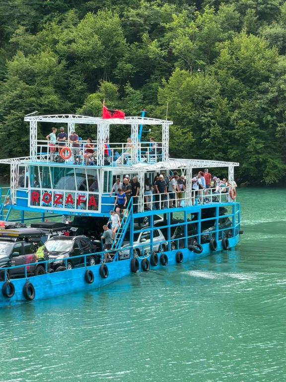 a ferry boat filled with people on the water at Drini Guesthouse in Tropojë