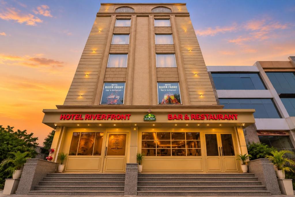 a building with a bar and restaurant in front at Hotel River Front in Kota